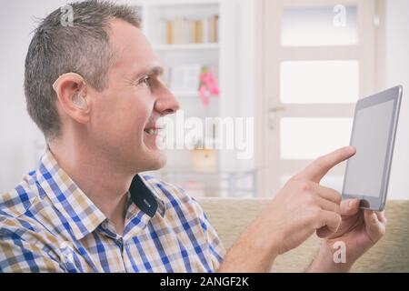 Smiling Deaf man talking using sign language on the tablets's cam Stock Photo