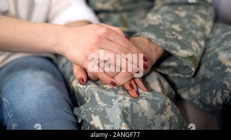 Military man and girlfriend holding hands, supporting boyfriend before leaving Stock Photo