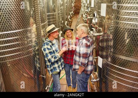 Group of winemakers tasting red wine in a winery Stock Photo