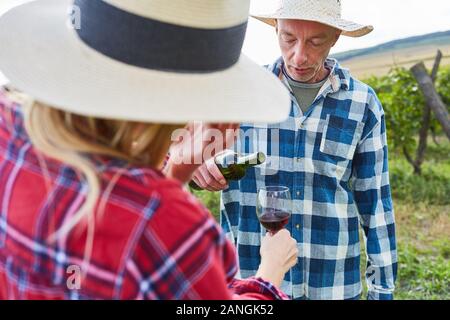 Couple tasting red wine in vineyard during wine harvest Stock Photo