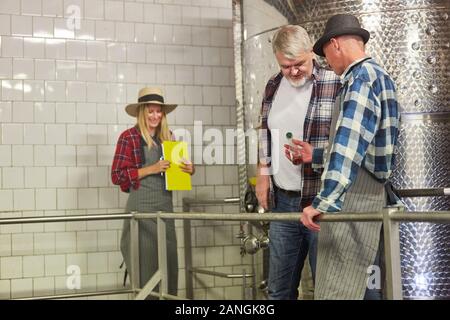 Winemakers and cellar masters discuss a sample of wine in the winery Stock Photo