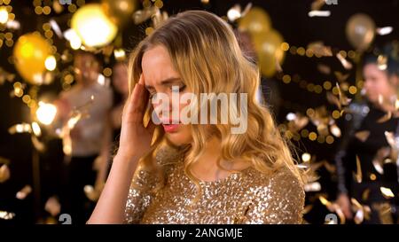 Beautiful woman having strong headache on party, loud music and alcohol overdose Stock Photo