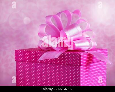A polka dots pink square box with beautiful shiny ribbon Stock Photo