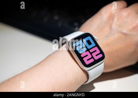 Chekhov, Russia - December 28, 2019: Apple Watch Series 4 white color with hand. A new watch from an Apple company closeup isolated on dark background Stock Photo
