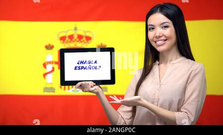 Woman holding tablet with do you speak spanish phrase, app for learning language Stock Photo