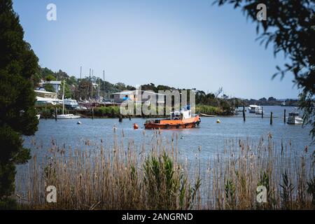 Launceston, Tasmania - January 3rd 2020: An orange fishing boat sits on the River Tamar. Taken from Kings Park. Stock Photo