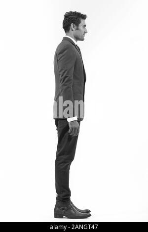 Profile view of full body shot of young handsome Persian businessman Stock Photo