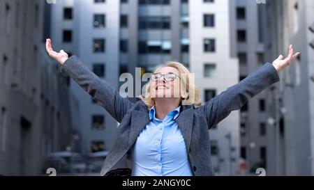 Cheerful company director raised hands up, life work satisfaction, free breath Stock Photo