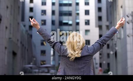 Elderly business woman standing back with raised hands up, career motivation Stock Photo