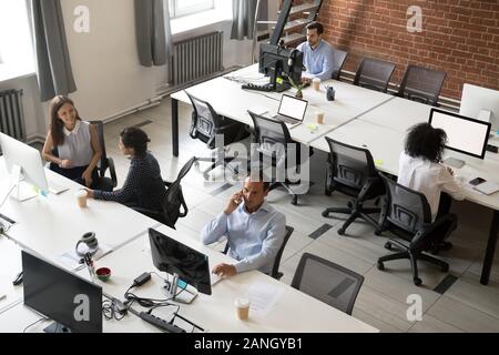 Top view of diverse company colleagues working together on pc in shared office, mixed workers or managers using computers or collaborating, busy in co Stock Photo