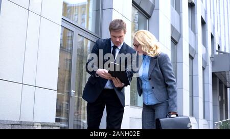 Busy businesswoman signing document outdoors, company manager approving report Stock Photo