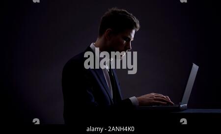Businessman working on laptop at night shift, overworking concept, workaholic Stock Photo