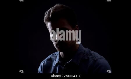 Young man looking at camera isolated on black background, personality dark side Stock Photo