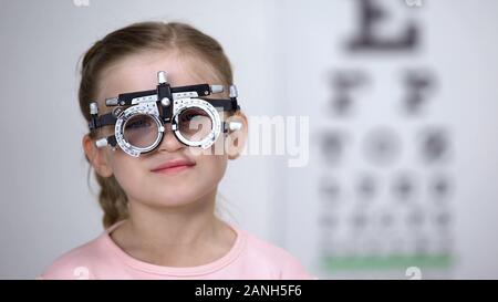 Little girl wearing eye testing glasses to diagnose vision, professional help Stock Photo