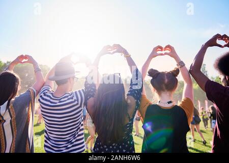 Rear view of friends making a heart with hands Stock Photo