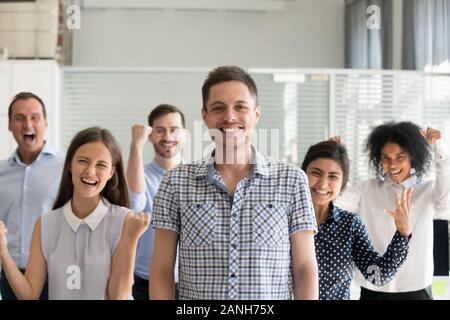Portrait of excited millennial Caucasian businessman pose with young multiracial team motivated for success, smiling overjoyed business group together Stock Photo