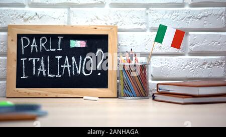 Do you speak Italian written on board, international flag in box, language Stock Photo