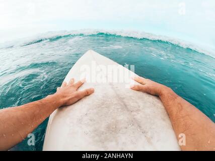 Young man having fun surfing on high waves ocean - Sporty surfer doing training exercises on blue water Stock Photo