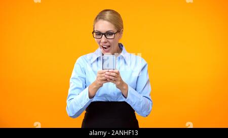 Young surprised business woman reading email on smartphone, successful deal Stock Photo