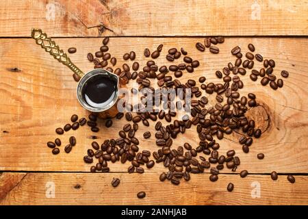 Turkish coffee maker and coffee grains on a rustic wooden table Stock Photo