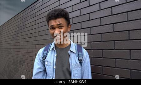 Black boy teasing looking mockingly into camera, emotional bullying in school Stock Photo
