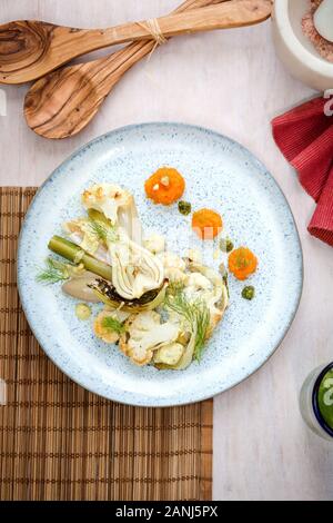 Vegan main course: Cauliflower steak with fennel and carrot puree. Wooden background and top view. Vegetarian food Stock Photo