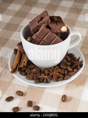 still life, installation, a cup with chocolate, coffee beans, anise and cinnamon sticks on a table Stock Photo
