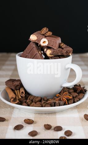 still life, installation, a cup with chocolate, coffee beans, anise and cinnamon sticks on a table Stock Photo