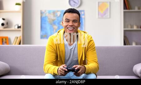 Game addicted Afro-American teenage boy winning computer game, procrastination Stock Photo