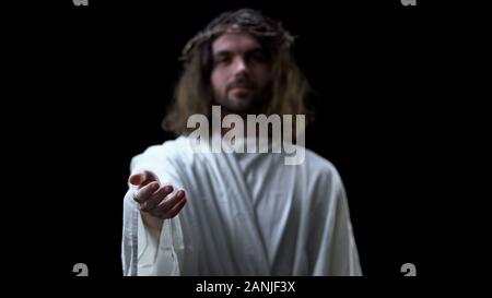 Helping hand of savior on dark background, religious help, forgiveness kindness Stock Photo
