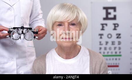 Happy senior female in eyeglasses looking at camera during vision examination Stock Photo