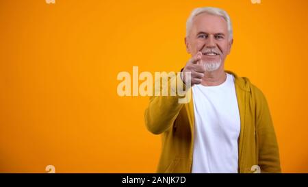 Confident modern senior man pointing finger on camera, welcoming to nursing home Stock Photo