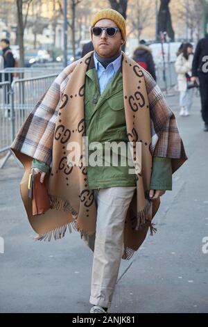 MILAN, ITALY - JANUARY 13, 2019: Man with beige Gucci scarf and olive green jacket before Fendi fashion show, Milan Fashion Week street style Stock Photo