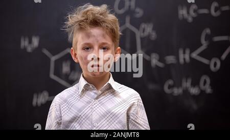 Funny dirty schoolboy feeling guilty after chemical experiment, looking to cam Stock Photo