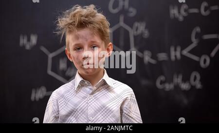 Sad dirty boy feeling guilty after explosion during chemical experiment, lesson Stock Photo