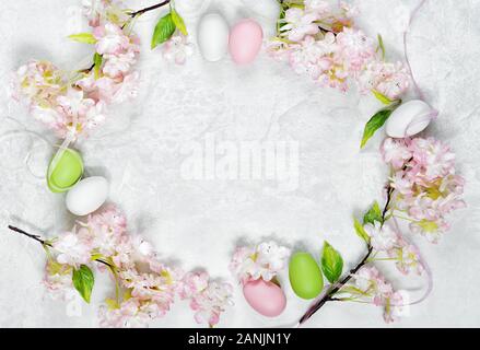 Beautiful delicate Easter composition with pink cherry flowers and multicolored Easter eggs Stock Photo