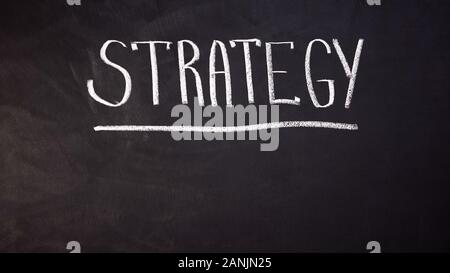 Strategy word written on blackboard, developing business, planning startup Stock Photo