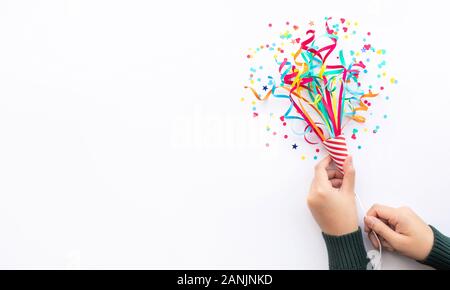 Celebration party and anniversary concepts ideas with woman hand holding colorful confetti,paper art on white color background.copy space Stock Photo