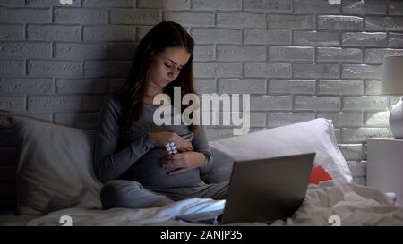 Expectant woman holding pills and stroking belly, vitamins for pregnant, health