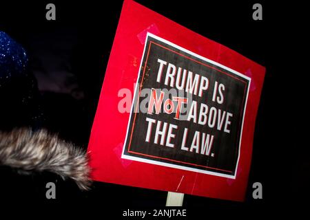 12-17-2019 Tulsa USA Woman in beanie cap and fur collar holds sign Trump is NOT Above the Law at night protest Stock Photo