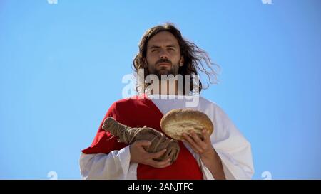 Jesus holding bread and bottle of wine, sharing sacramental meal, Holy Eucharist Stock Photo