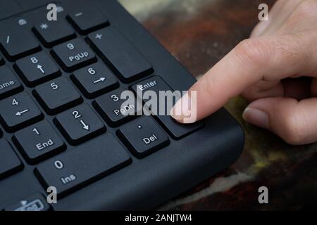 Close up Index finger push button Enter on the computer keyboard Stock Photo
