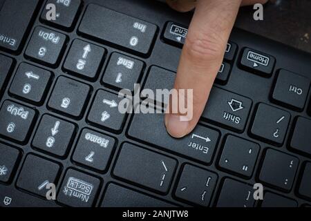 Close up female Index finger typing on the computer keyboard Stock Photo