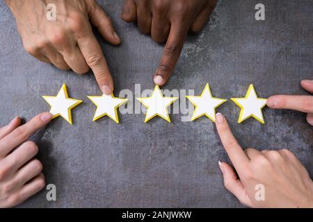Person Hands Aligning Five Star Rating Icons. High Angle View Stock Photo