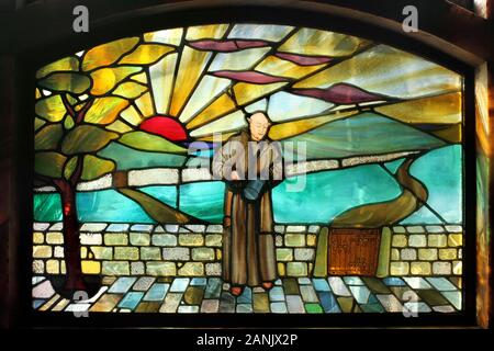 Coloured glass window depicting a friar with a sunny landscape behind, in The Black Friar pub, Blackfriars, London. Stock Photo