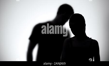 Silhouettes of upset woman and man together, experiencing life difficulties Stock Photo