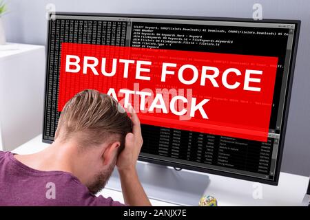 Sider View Of An Upset Businessman Looking At Computer Screen With Brute Force Attack Message Stock Photo