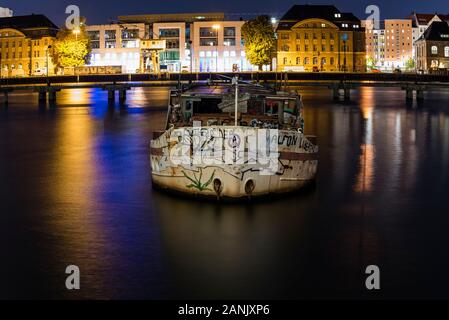 Old big boat that ran aground, an old boat lies on the ground, night shot, colorful, Berlin, Treptow harbor Stock Photo