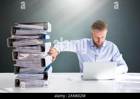 Businessperson Pushing Paper Documents Away And Working With Digital Documents On Computer Instead Stock Photo