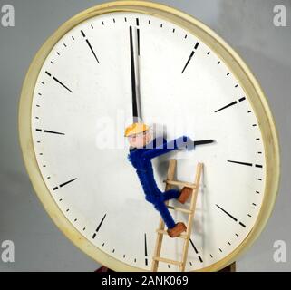 Clockman adjusting a clock to or back from Daylight Saving Time (DST) Stock Photo